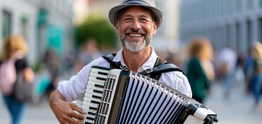 Man playing accordion at an international street theatre festival in a city, smiling performer, festive outdoor event, defocused crowd background, with copy space